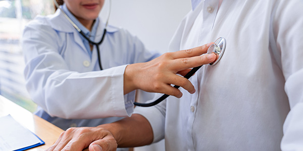 doctor checking heart beat